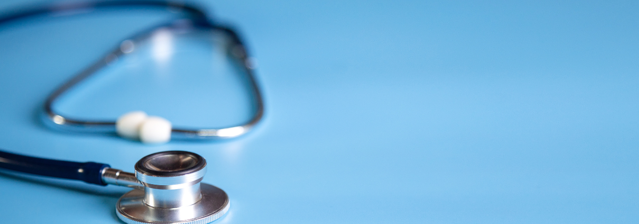 blue background with stethoscope laying flat in focus