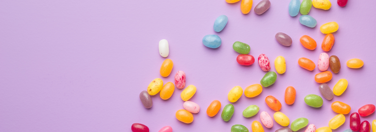 purple background with colourful jelly beans scattered across background