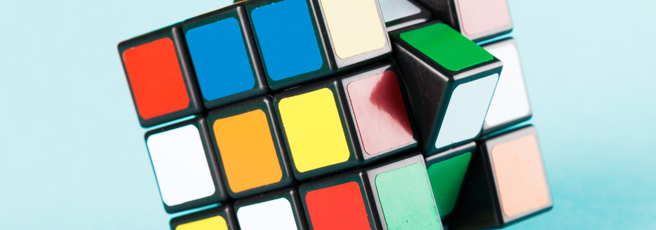 Close up of rubix cube twisting, against light blue background