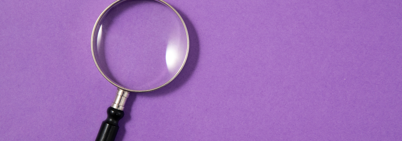 Purple background with magnifying glass as focus