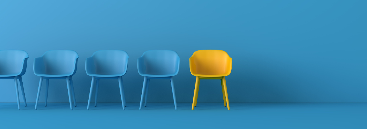 Blue chairs lined up with yellow chair as focal point in the centre