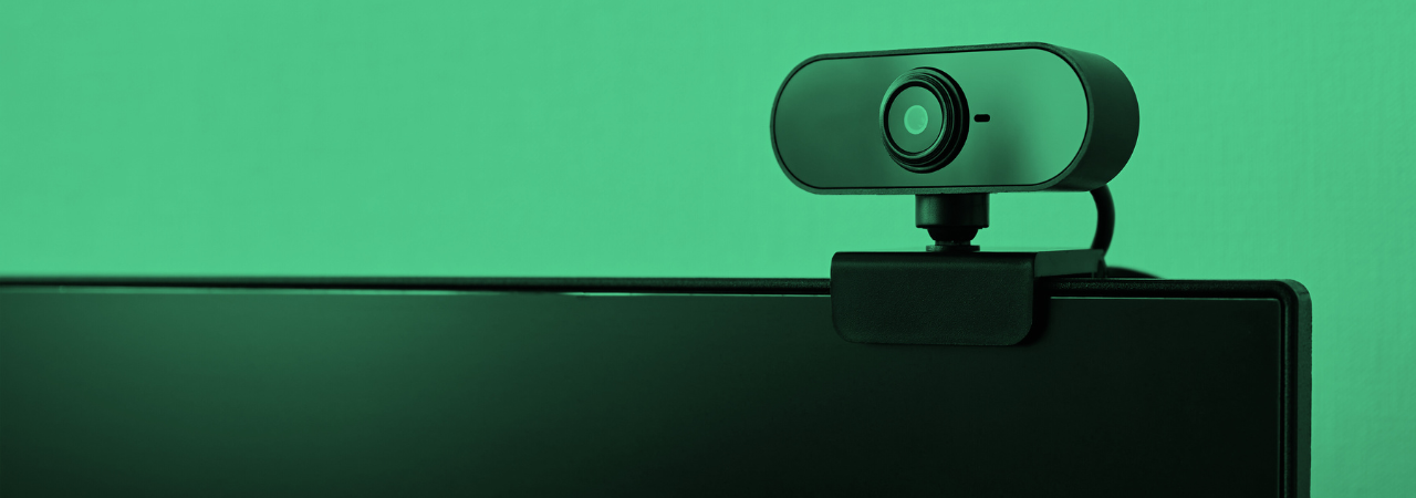 green filter over image of small rounded rectangular webcam sitting on a computer monitor