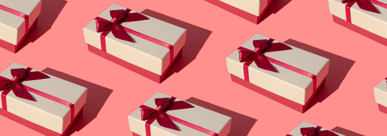 Salmon pink background with repeated motif of white and red ribboned gift boxes